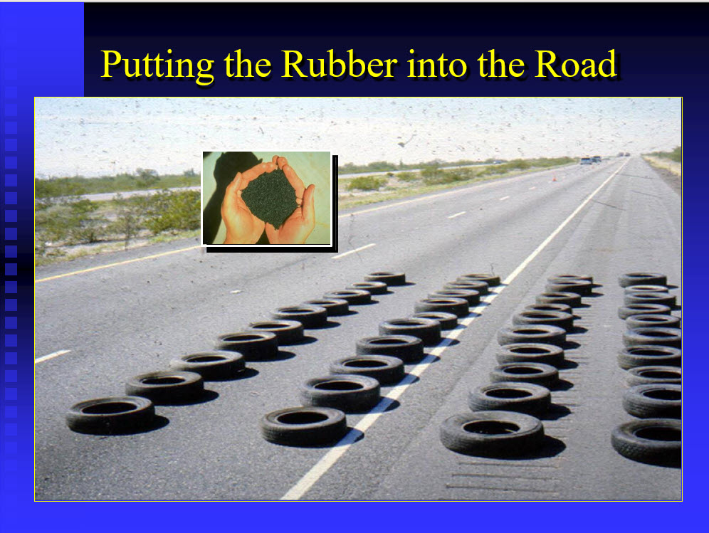Scrap tires and crumb rubber staged on a road, illustrating the source material for rubberized asphalt